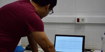 Clinical neurophysiologist reviewing EEG waveform data